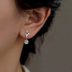 Model showcasing the dangle and style of the Sterling Silver Zircon Maple Leaf Earrings