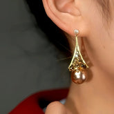Gold fan-shaped champagne crystal brown pearl drop earring on woman's ear