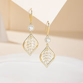 Pair of gold CZ leaf-shaped drop dangle earrings on neutral paper display