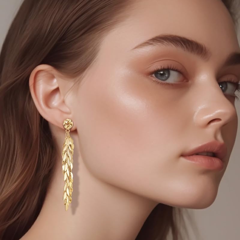 Woman wearing long gold leaf tassel dangle drop earrings