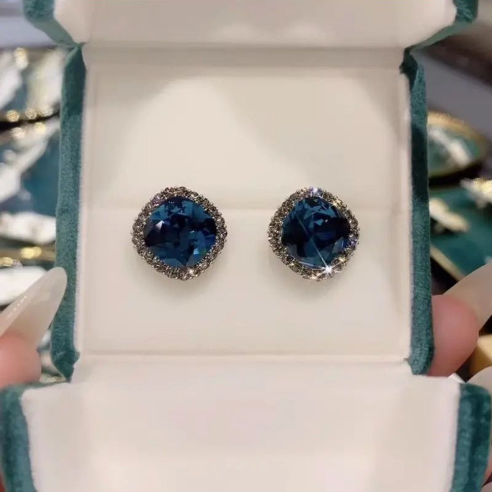 Dark blue cushion cut crystal stud earrings in green velvet jewelry box