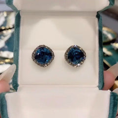 Dark blue cushion cut crystal stud earrings in green velvet jewelry box