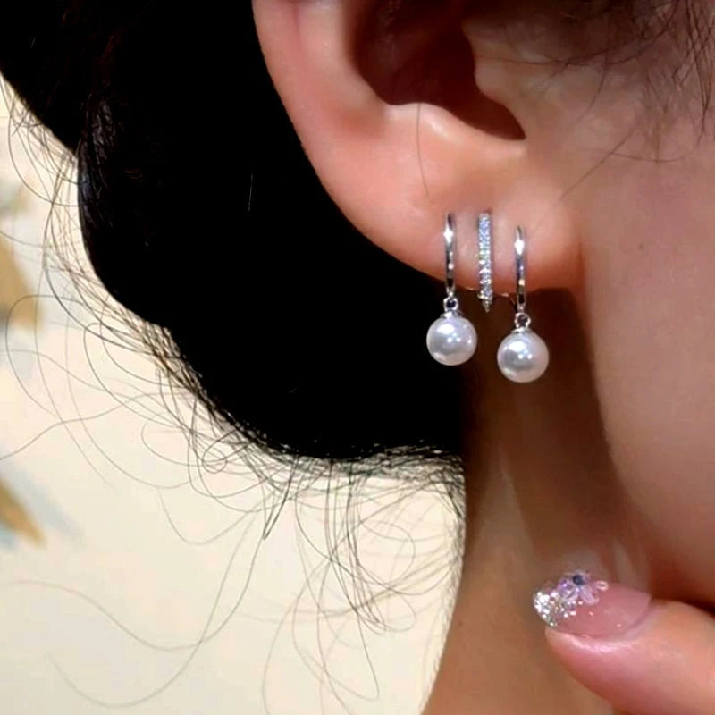 Model showcasing the dangle and style of the 14K Gold-Plated Elegant Multi-Layer Pearl Earrings