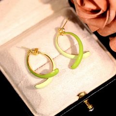 Model showcasing the dangle and style of the 14K Gold-Plated Elegant Oil Drop Fishtail Earrings