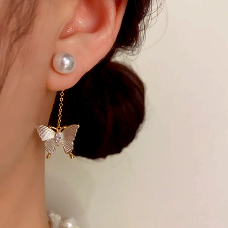 Model showcasing the dangle and style of the 14K Gold-Plated Elegant Zircon Butterfly Pearl Tassel Earrings