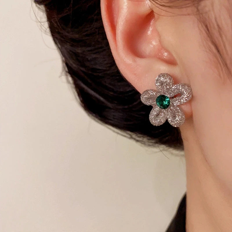 Model showcasing the dangle and style of the 14K Gold-Plated Elegant Zircon Hollow Flower Stud Earrings