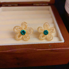 Close-up detail of the sparkling zircons and plating on the gold flower earrings
