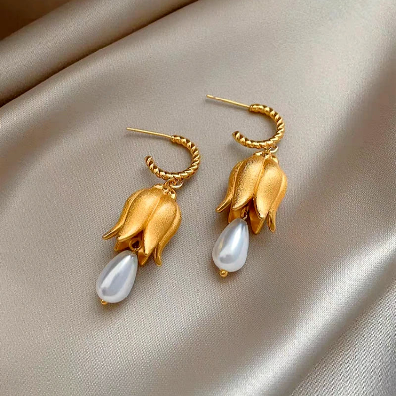 Model showcasing the dangle and style of the 14K Gold-Plated Lily Of The Valley Water Drop Pearl Earrings