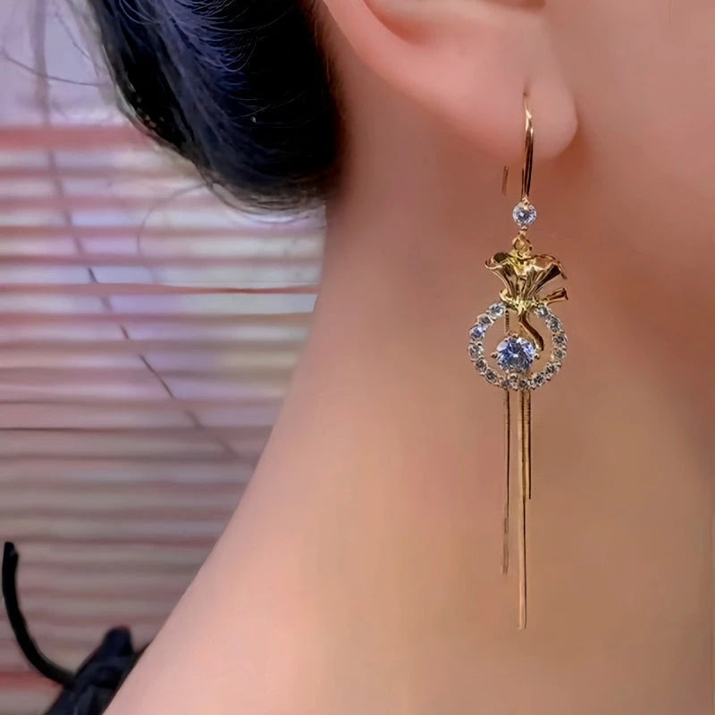 Model showcasing the dangle and style of the 14K Gold-Plated Luxury Zircon Diamond Lucky Bag Tassel Ear Hook Earrings