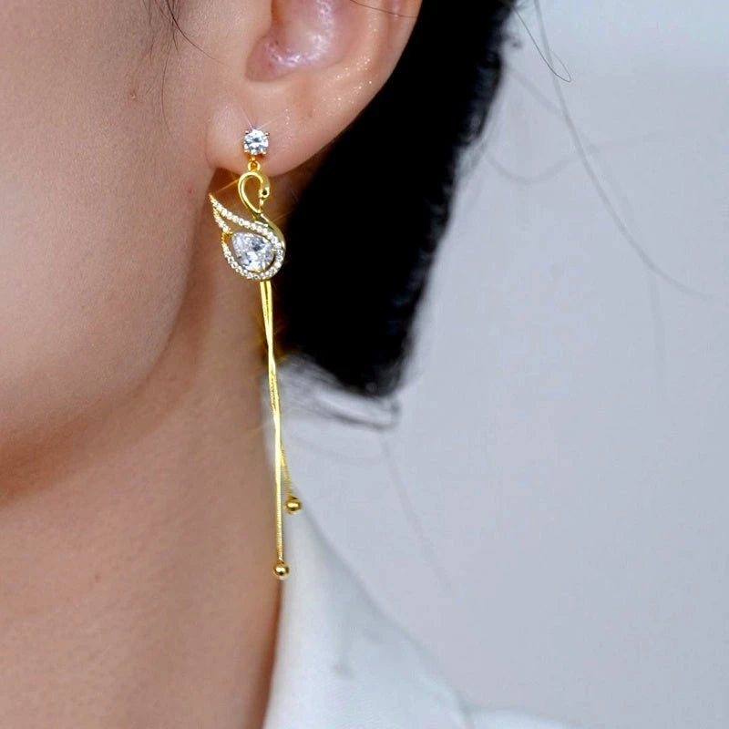 Model showcasing the dangle and style of the 14K Gold-Plated Elegant Zircon Diamond Swan Tassel Earrings