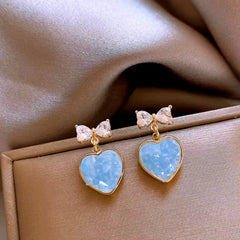 Close-up detail of the sparkling zircons and plating on the Heart Bow Earrings