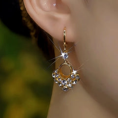 Model showcasing the dangle and style of the 14K Gold-Plated Zircon Shiny Diamond Earrings