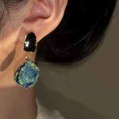 Close-up detail of the sparkling zircons and plating on the gold drop earrings