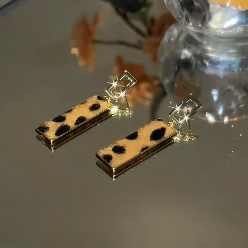 Close-up detail of the sparkling zircons and plating on the gold geometric earrings