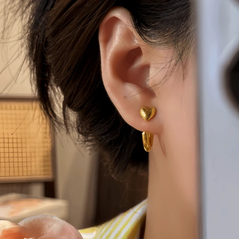 Model showcasing the dangle and style of the 14K Gold-Pated Heart-Design Jacket Earrings
