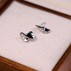 Model showcasing the dangle and style of the 14K Gold-Pated Twisted Irregular Stud Earrings