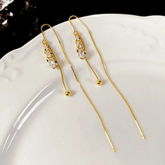 Angled view of the 14K Gold-Pated Zircon Ball Threader Tassel Earrings