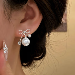 Model showcasing the dangle and style of the 14K Gold-Pated Zircon Bow Bead Earrings