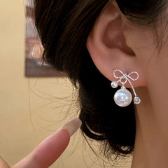 Close-up detail of the sparkling zircons and plating on the gold bow earrings