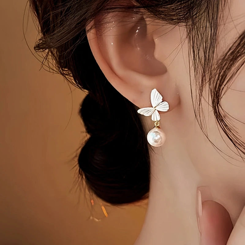Model showcasing the dangle and style of the 14K Gold-Plated 2025 Elegant White Butterfly Pearl Earrings