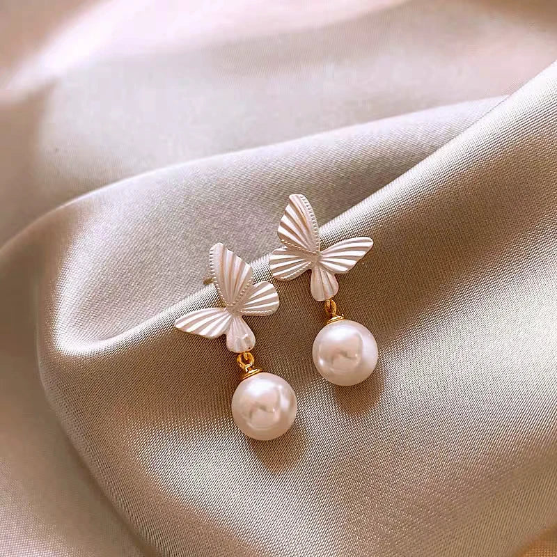 Close-up detail of the sparkling zircons and plating on the gold butterfly earrings