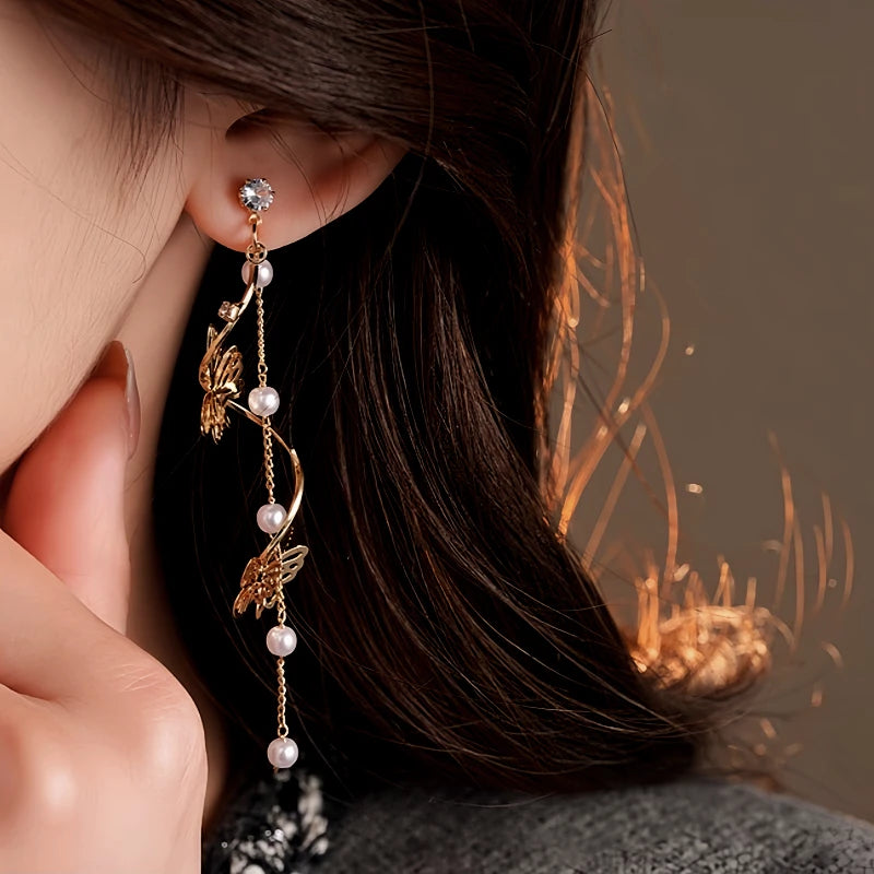 Model showcasing the dangle and style of the 14K Gold-Plated 2025 Elegant Zircon Butterfly Pearl Tassel Earrings