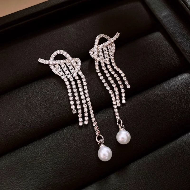 Model showcasing the dangle and style of the 14K Gold-Plated 2025 Elegant Zircon Diamond Knotted Pearl Tassel Earrings