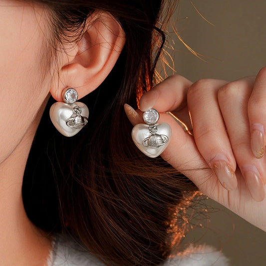 Model showcasing the dangle and style of the 14K Gold-Plated 2025 Elegant Zircon Pearl Heart Saturn Earrings