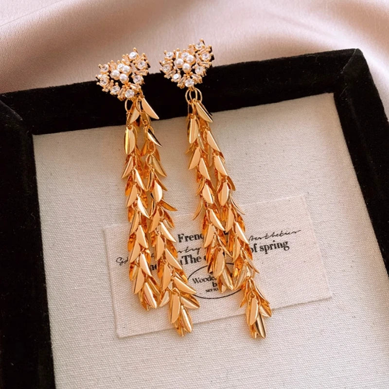 Close-up detail of the sparkling zircons and plating on the gold tassel earrings