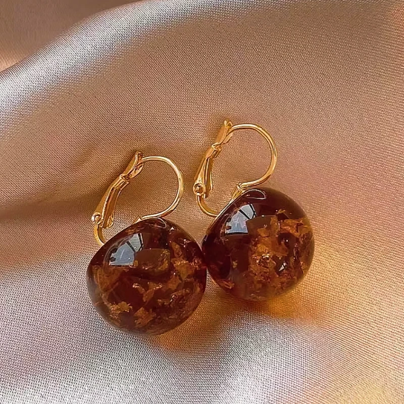 Angled view of the 14K Gold-Plated Amber Transparent Ball Earrings