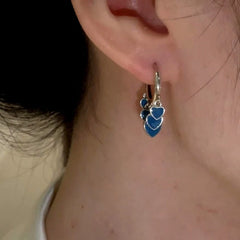 Model showcasing the dangle and style of the 14K Gold-Plated And Sterling Silver Blue Heart Tassel Earrings