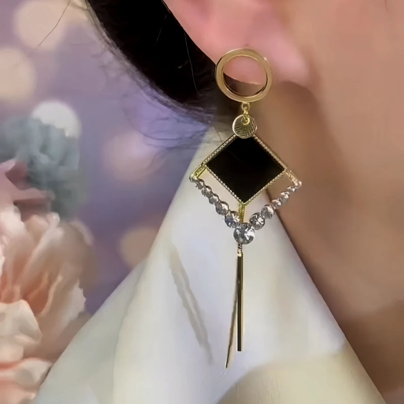 Model showcasing the dangle and style of the 14K Gold-Plated Asymmetrical Geometric Diamond Tassel Earrings