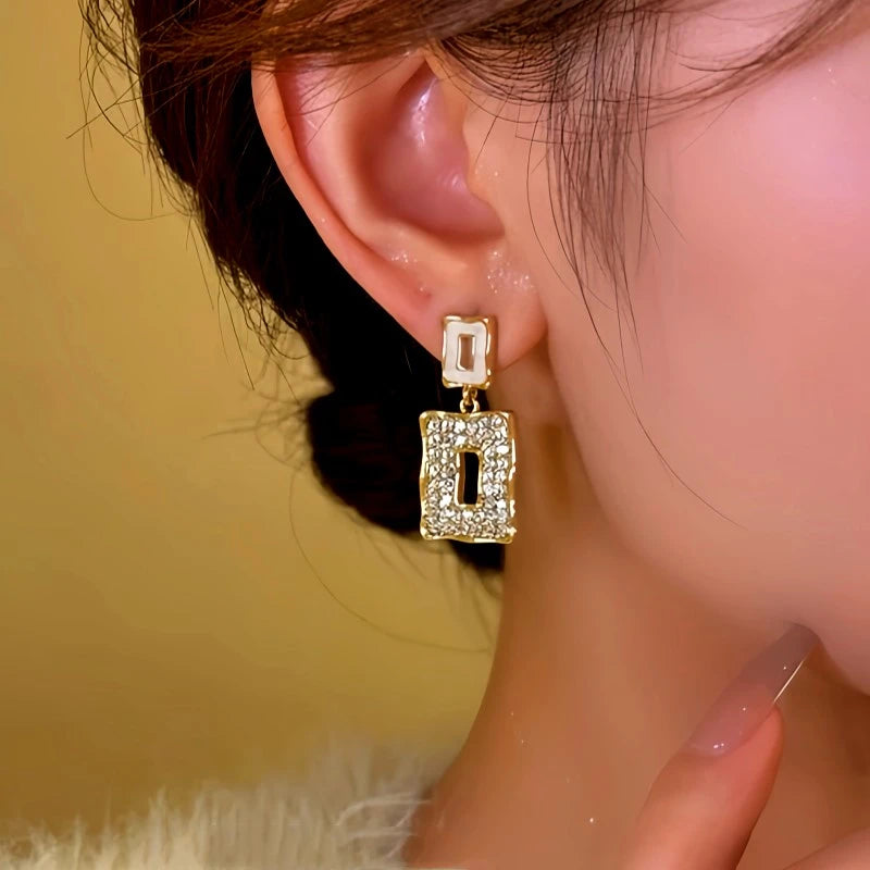 Close-up detail of the sparkling zircons and plating on the gold geometric earrings
