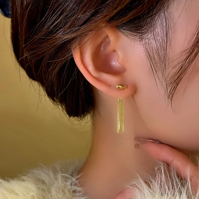 Close-up detail of the sparkling zircons and plating on the gold tassel earrings