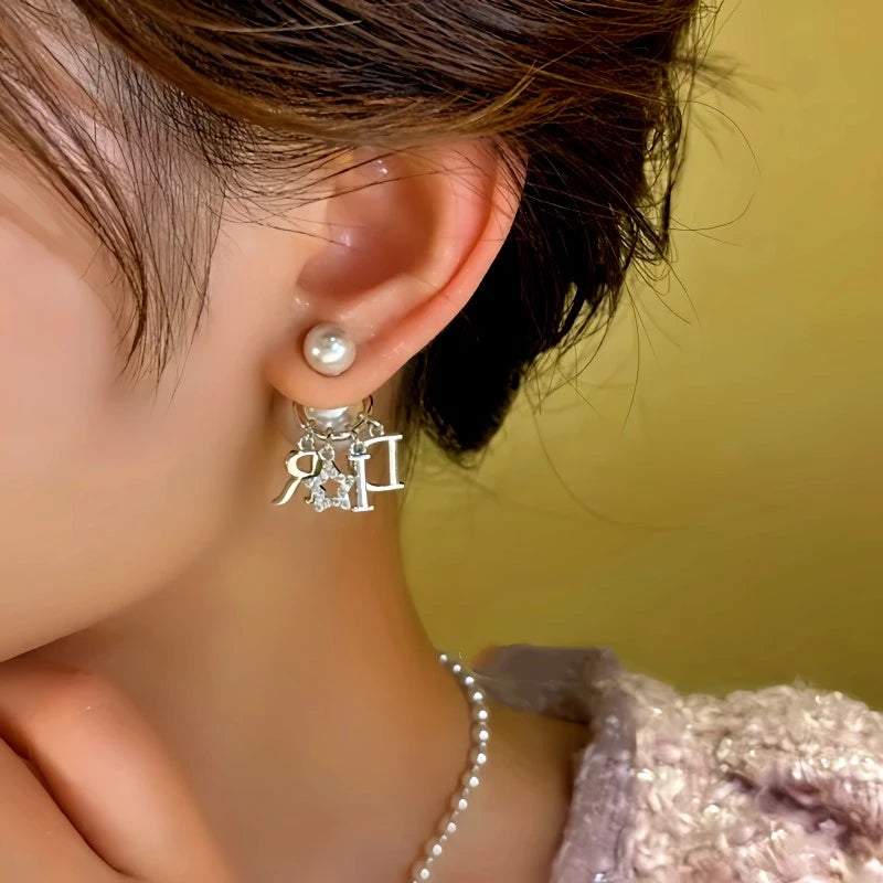 Model showcasing the dangle and style of the 14K Gold-Plated Bead Letter Tassel Earrings