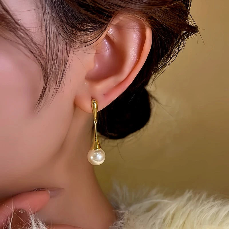 Model showcasing the dangle and style of the 14K Gold-Plated Bead Tassel Earrings