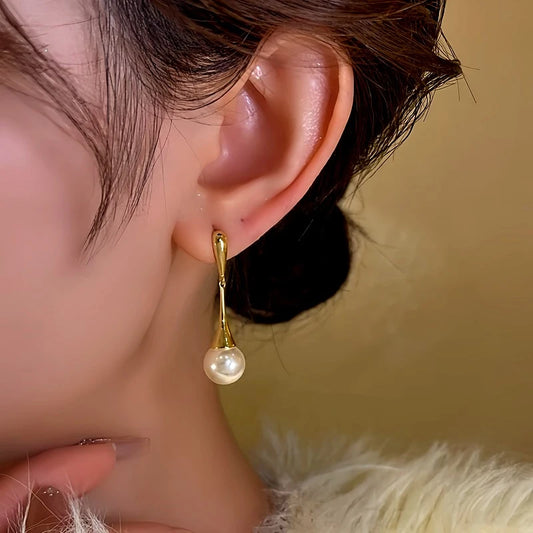 Model showcasing the dangle and style of the 14K Gold-Plated Bead Tassel Earrings