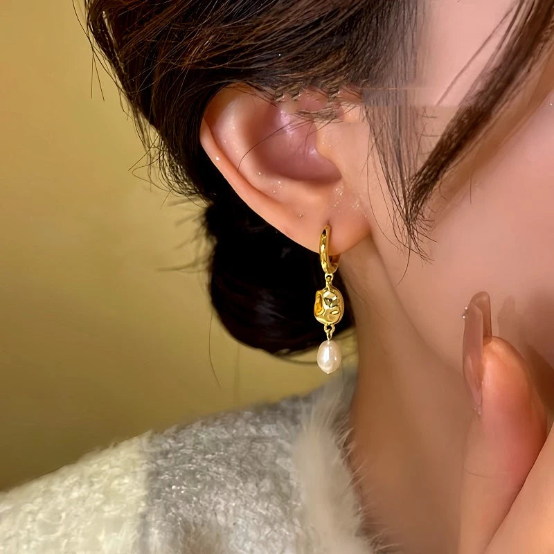 Close-up detail of the sparkling zircons and plating on the gold pearl earrings