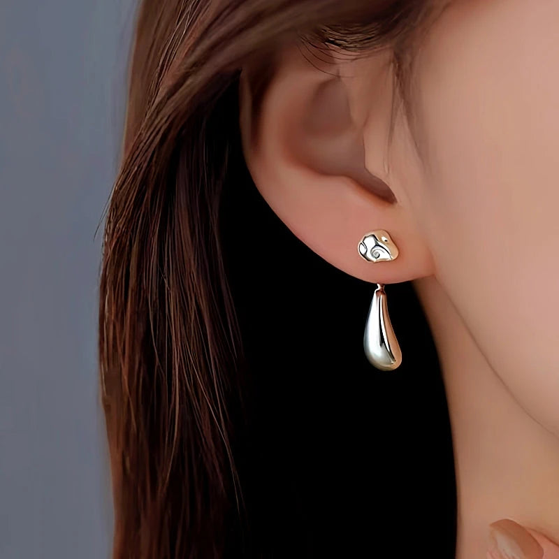 Model showcasing the dangle and style of the 14K Gold-Plated Bean Drop Earrings