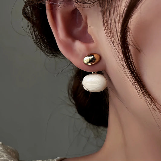 Model showcasing the dangle and style of the 14K Gold-Plated Bean Earrings