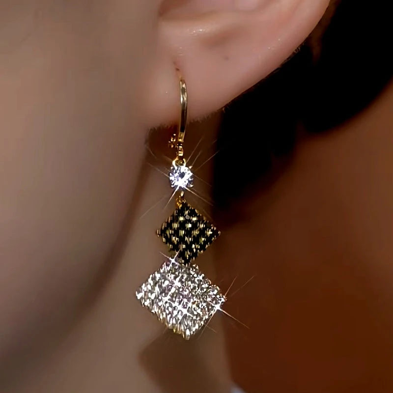 Model showcasing the dangle and style of the 14K Gold-Plated Black And White Double-Layer Diamond Earrings