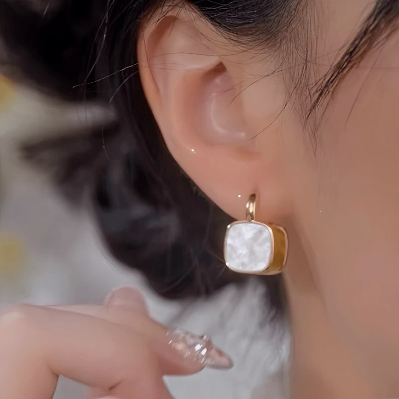 Close-up detail of the sparkling zircons and plating on the gold drop earrings