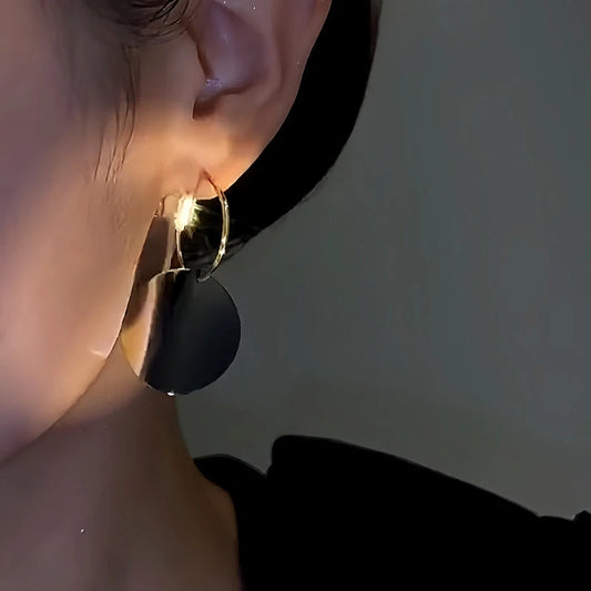 Model showcasing the dangle and style of the 14K Gold-Plated Black And White Tassel Earrings