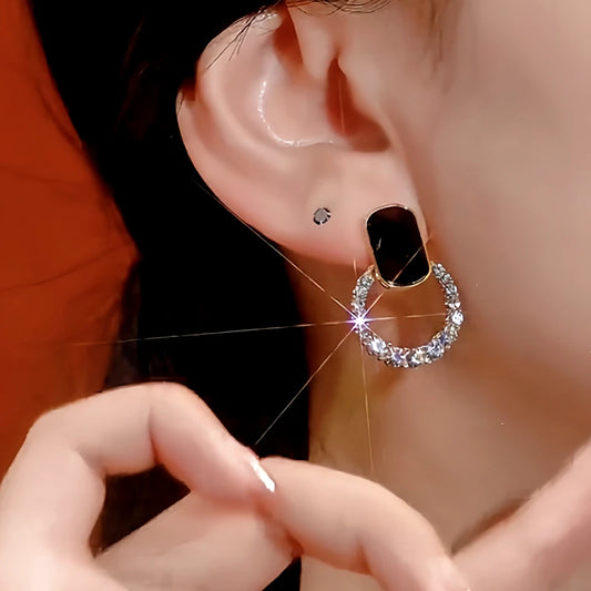 Model showcasing the dangle and style of the 14K Gold-Plated Black Crystal Hoop Diamond Earrings