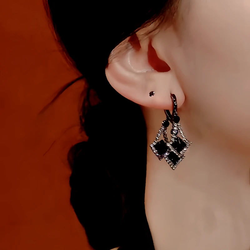 Model showcasing the dangle and style of the 14K Gold-Plated Black Crystal Tassel Earrings