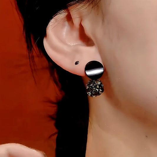 Model showcasing the dangle and style of the 14K Gold-Plated Black Diamond Ball Earrings