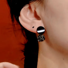 Model showcasing the dangle and style of the 14K Gold-Plated Black Diamond Ball Earrings