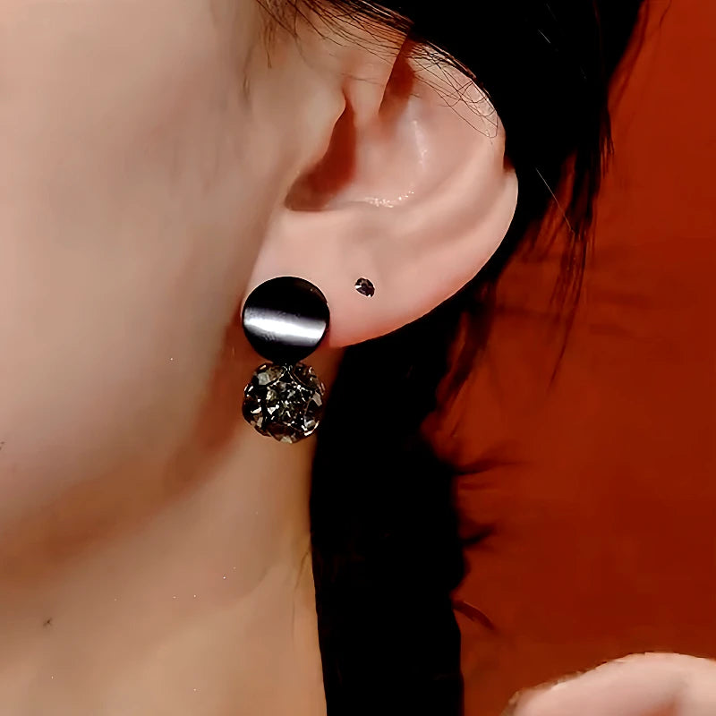 Close-up detail of the sparkling zircons and plating on the gold drop earrings