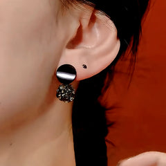 Close-up detail of the sparkling zircons and plating on the gold drop earrings