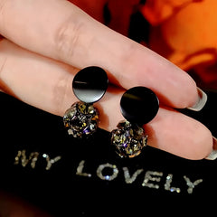 Angled view of the 14K Gold-Plated Black Diamond Ball Earrings